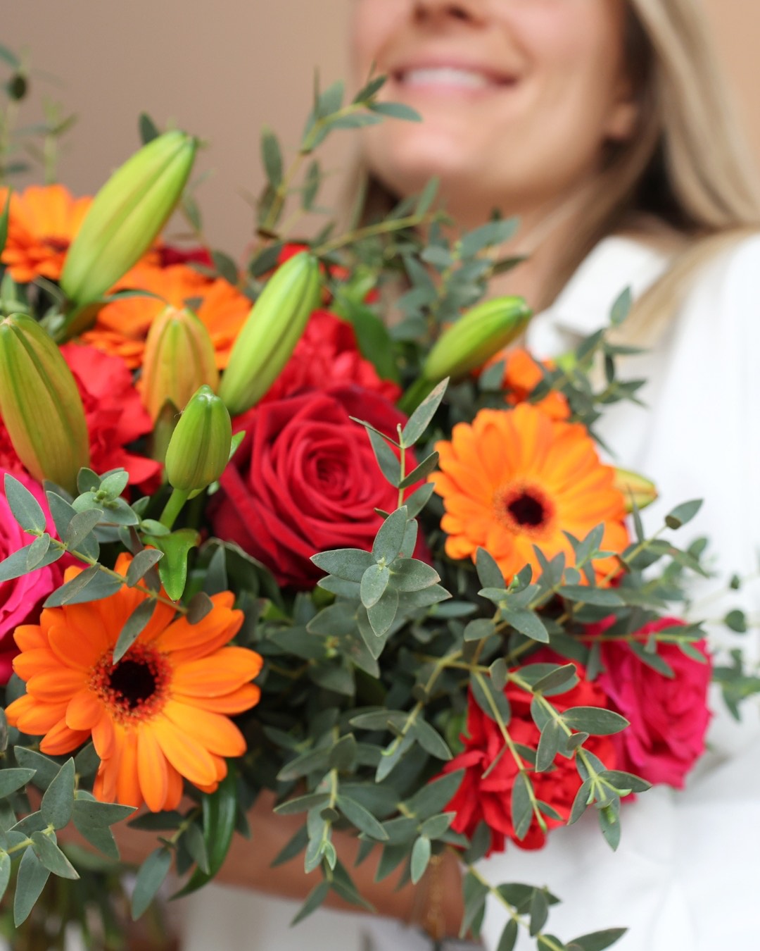 L'équipe Daily-flowers présente un bouquet coloré (roses rouges, gerberas oranges, lys, eucalyptus)